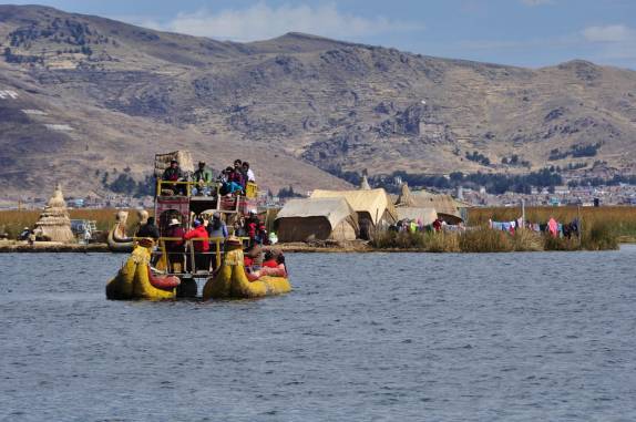 Os Uros levam turistas para passear em barco típico, nas Islas flotantes do lago Titicaca, perto de Puno, no Peru